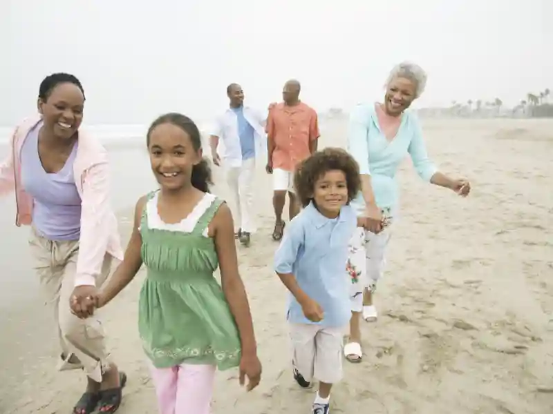 Multi-generational family walking at beach.