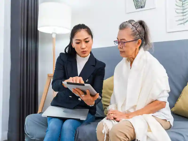 An insurance consultant visiting senior woman at home.