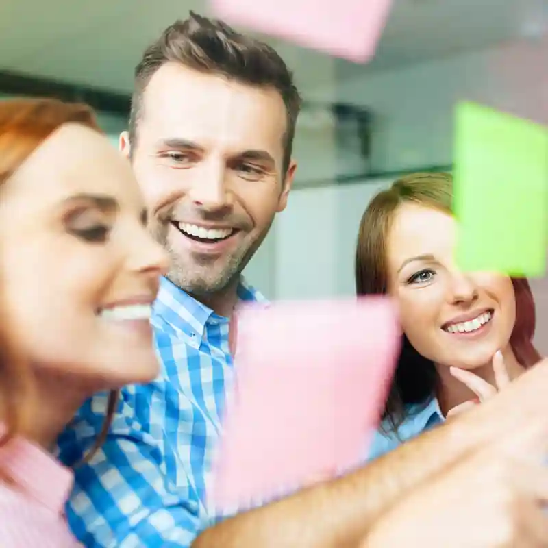 Group of business people working on new project with many sticky notes on window