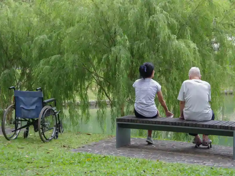 Elderly man and his caregiver on a walk in a park.
