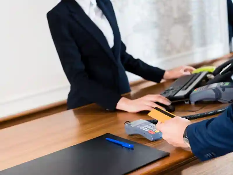 Man paying while holding credit card in hotel.