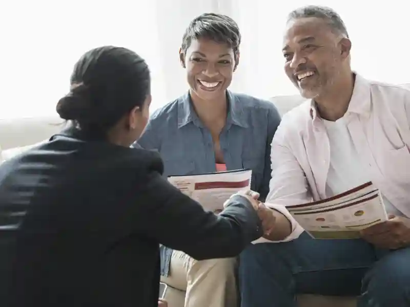 African American couple talking to businesswoman.