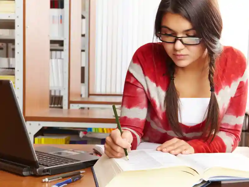 College student studying in library.