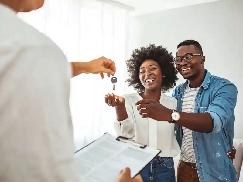 Close up of happy homeowners receiving their new house keys from a estate agent.