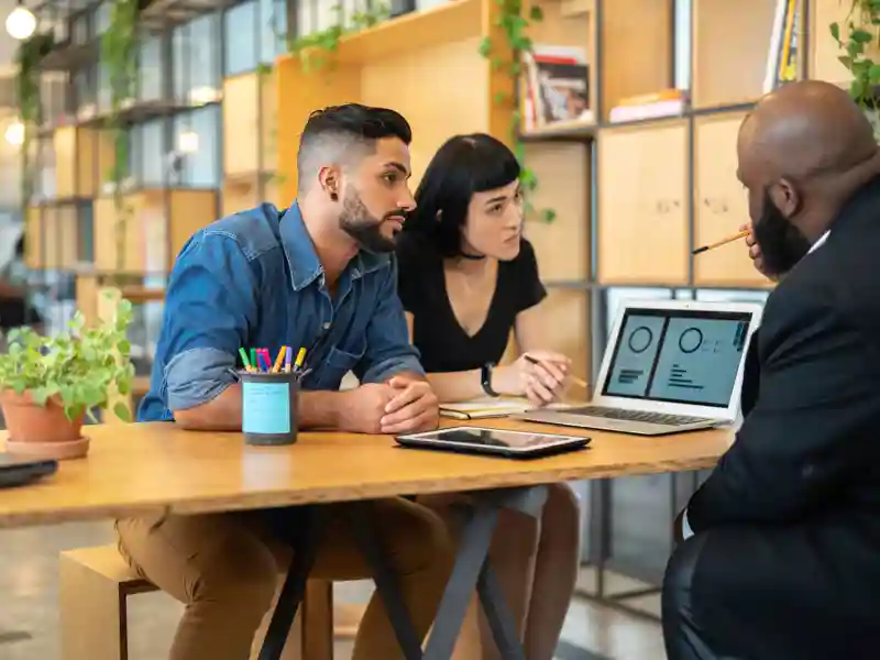 Agent talking to a couple in the office.