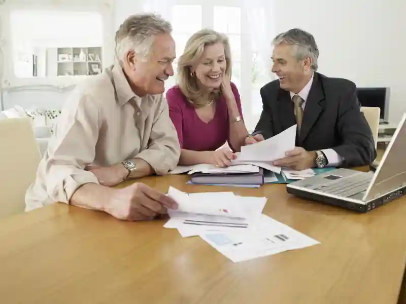 Mature couple sitting at table with financial advisor.