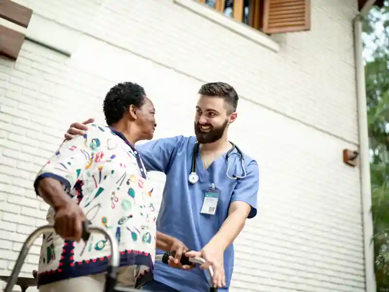 Home caregiver helping senior woman to walk.