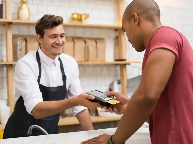 Man making payment in cafeteria with credit card.
