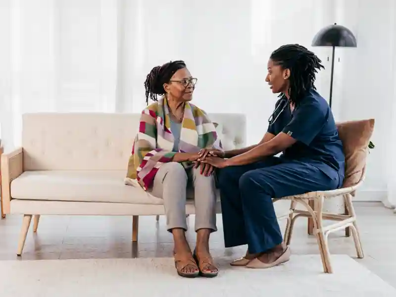 In-home nurse sitting with elderly woman.